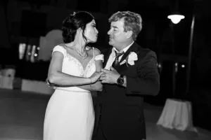 Professional Photographer A bride and an older man, likely her father, share a joyful dance outdoors at night. Smiling in formal attire, they create a timeless moment—captured in black and white—showcasing the artistry of wedding photography and portrait elegance. www.maranonimagery.com