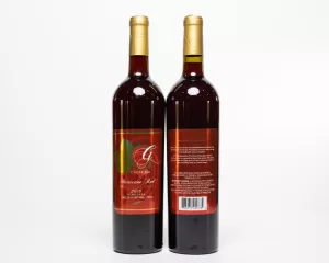 Professional Photographer Two tall wine bottles with gold foil tops and red labels, shown front and back like elegant portaits. The front label reads Grancreo Red 2019; the back shows product details and a barcode. Both bottles stand on a white background. www.maranonimagery.com