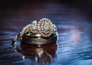 Professional Photographer A close-up of a sparkling diamond engagement ring and wedding band resting on a polished wooden surface, with intricate details and reflections visible—perfect for adding elegance to portraits or engagement headshots. www.maranonimagery.com