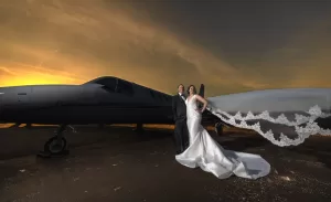 Professional Photographer A bride and groom stand in front of a sleek private jet at sunset, captured in stunning wedding photography. The bride’s veil flows in the wind as warm orange hues dramatize this unforgettable portrait. www.maranonimagery.com