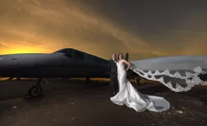 Professional Photographer A bride and groom stand in front of a private jet at sunset, captured by a skilled wedding photographer. The bride’s white gown and flowing veil glow against the dramatic orange and gold sky, creating unforgettable wedding photography portraits. www.maranonimagery.com